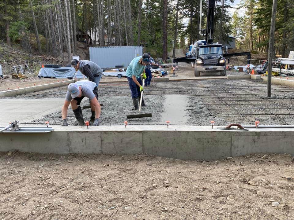 Men pouring and raking concrete